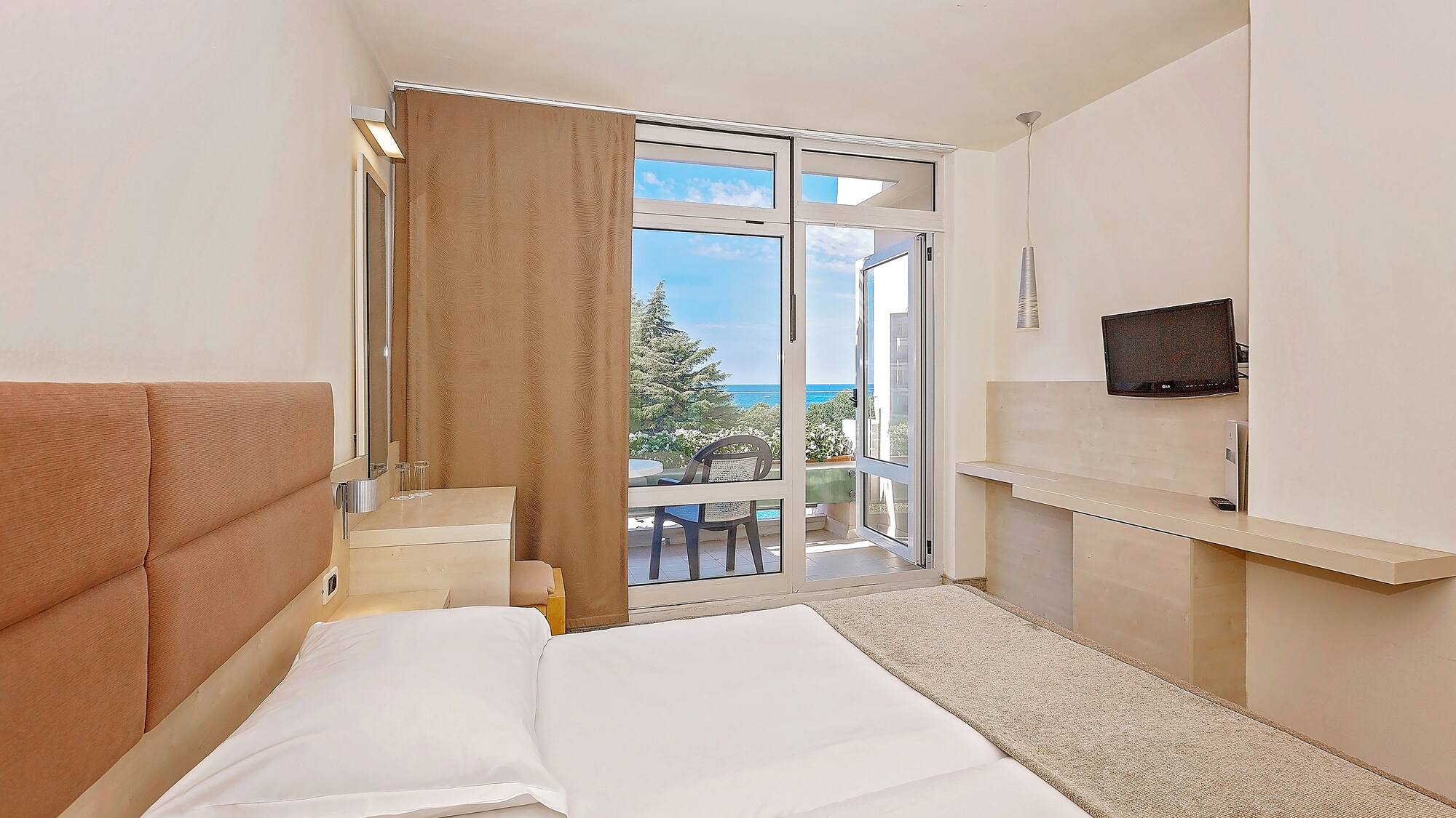 a bedroom with a large bed and a glass door