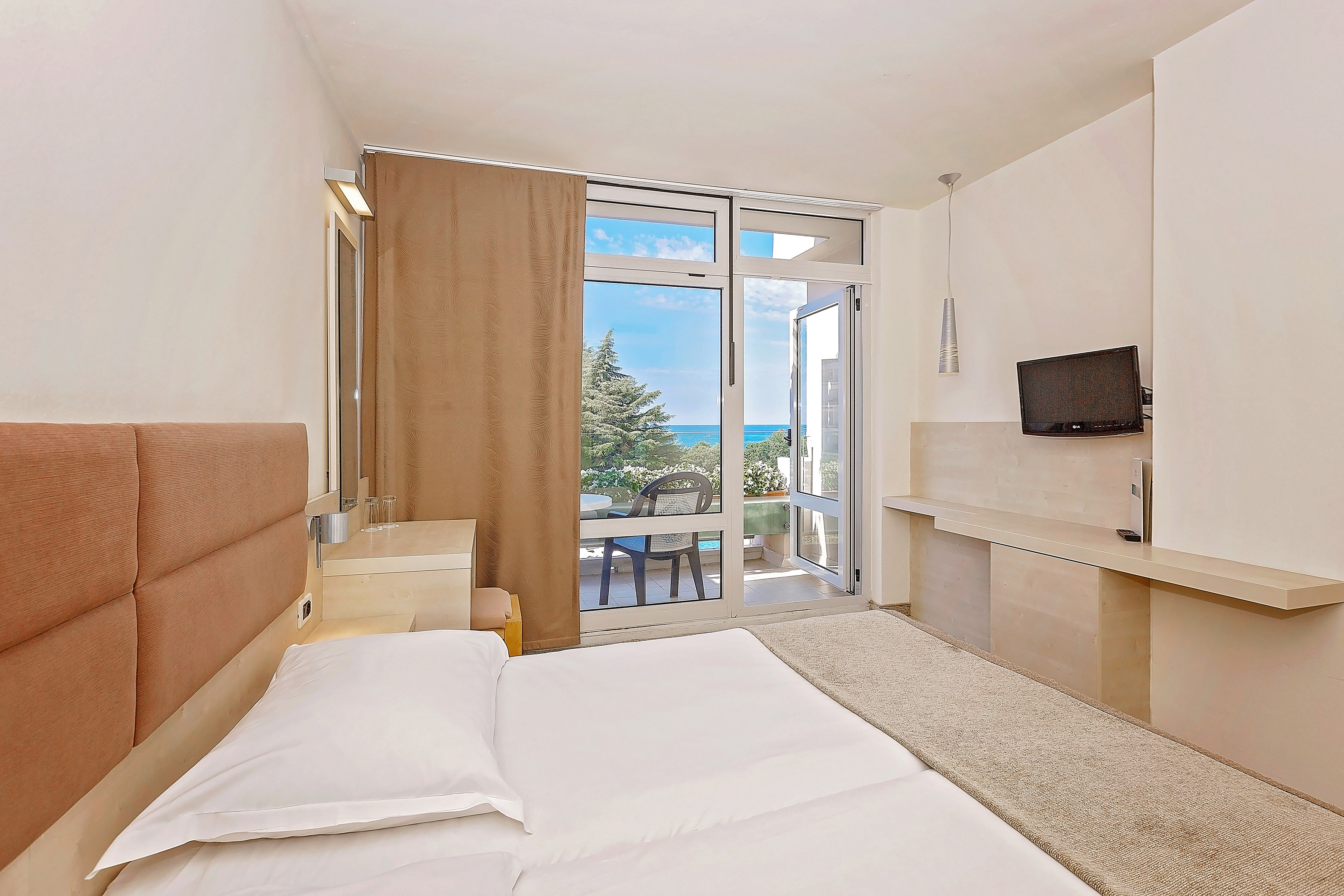 a bedroom with a large bed and a glass door