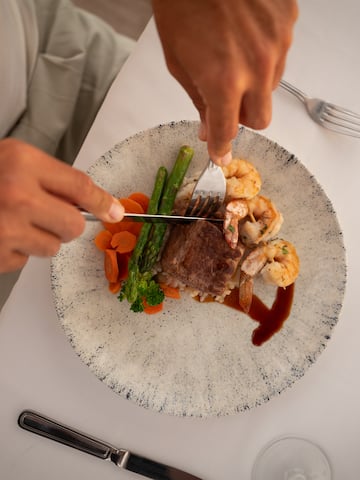 a person cutting a plate of food