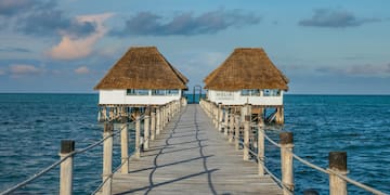 a dock leading to two huts