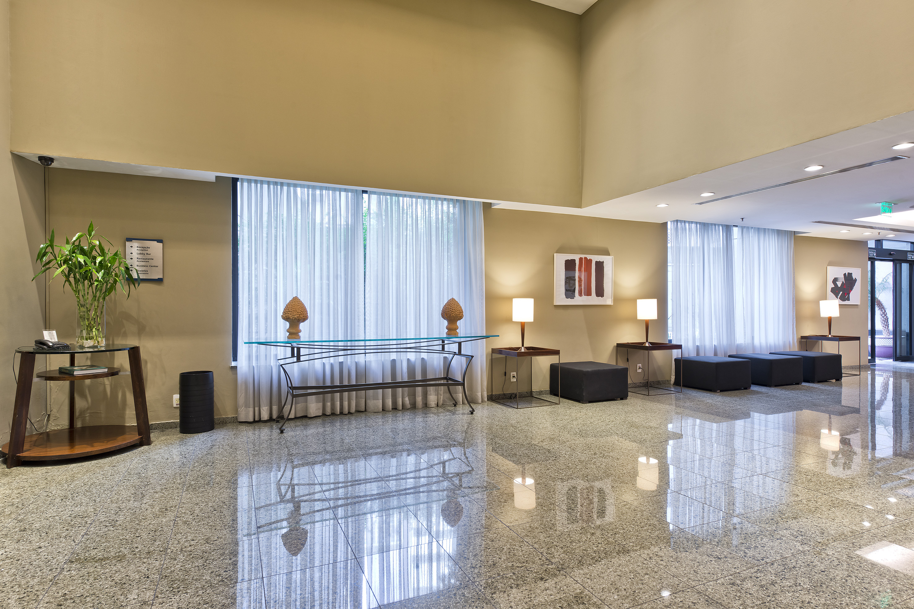 Hotel lobby with polished granite floor, modern decor, and bright windows.