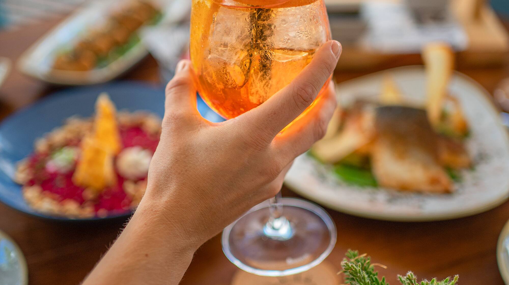 a hand holding a glass of drink with a straw