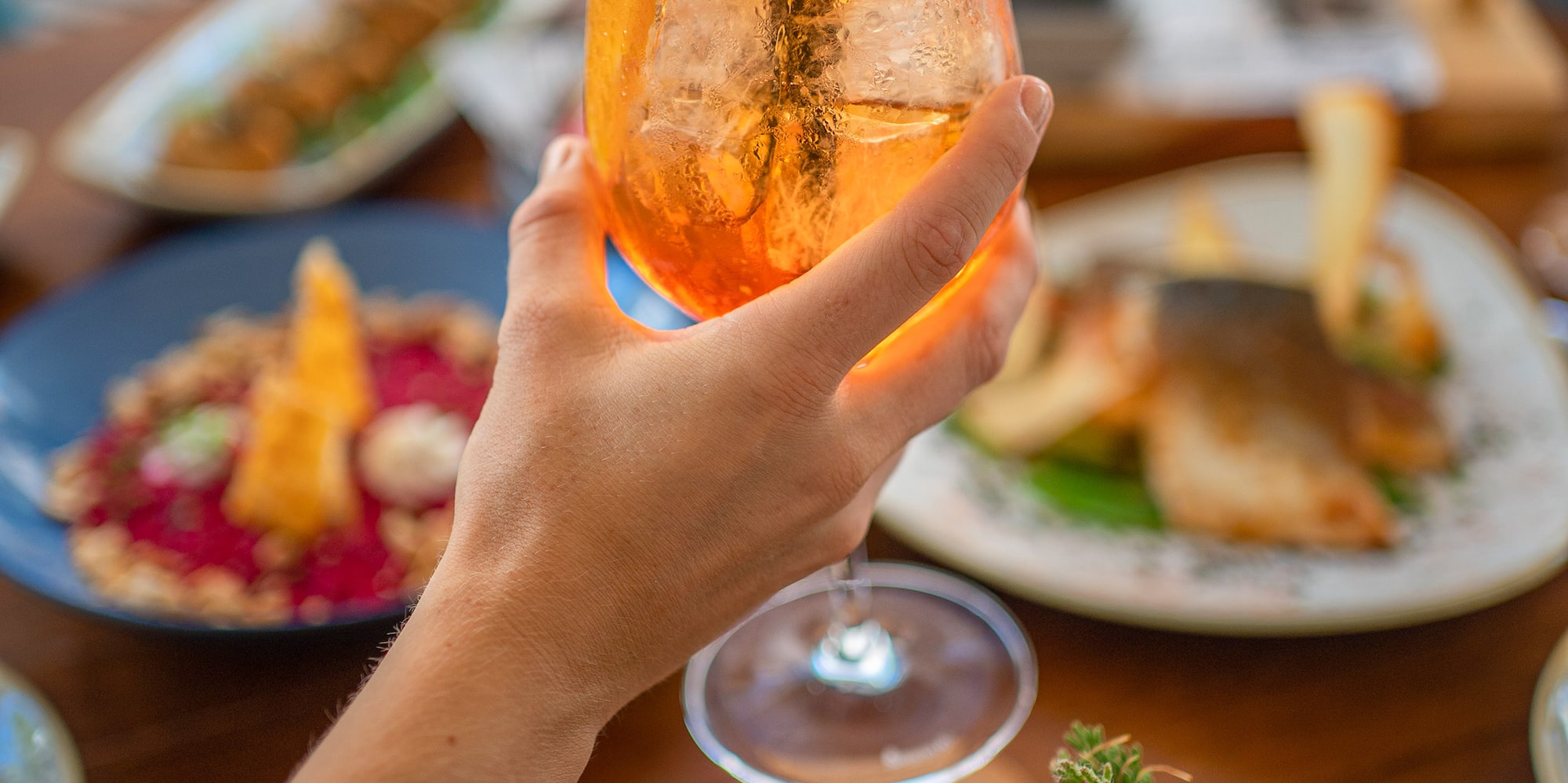 a hand holding a glass of drink with a straw