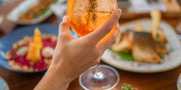 a hand holding a glass of drink with a straw