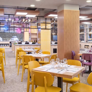 a restaurant with yellow chairs and tables