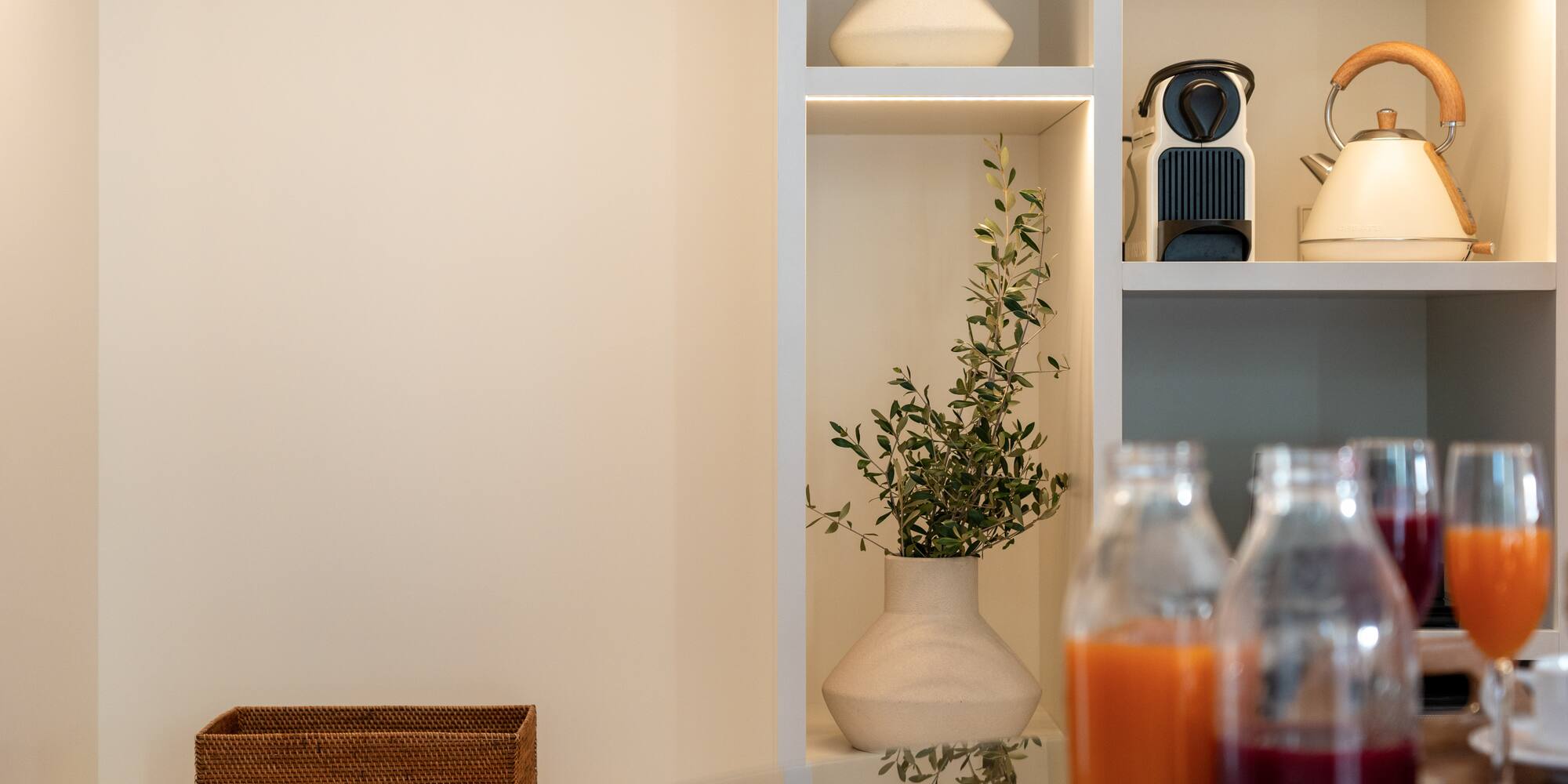 a shelf with a plant and bottles of juice