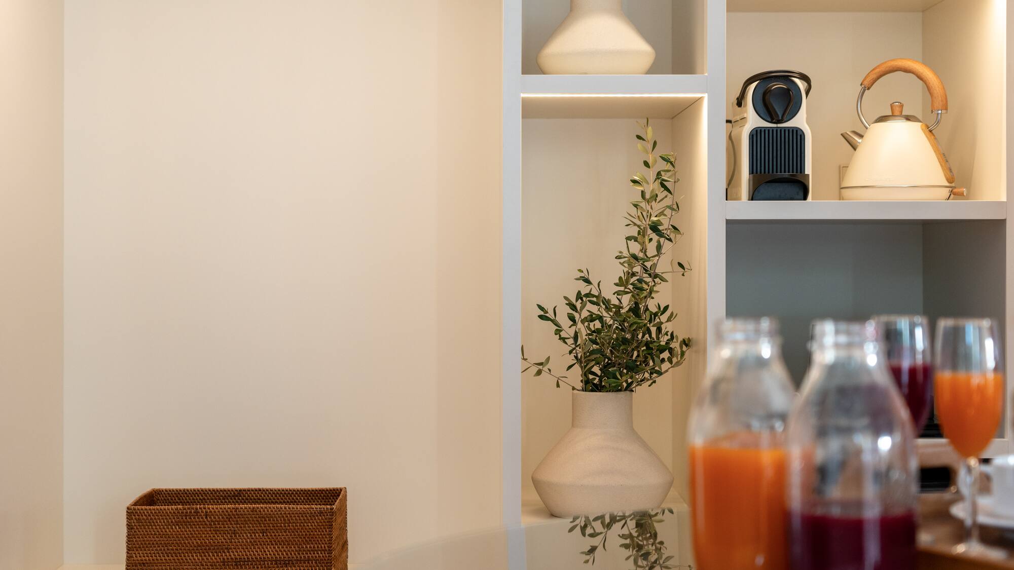 a shelf with a plant and bottles of juice