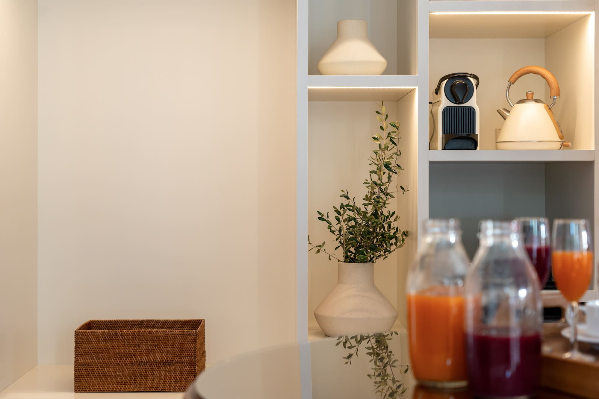 a shelf with a plant and bottles of juice