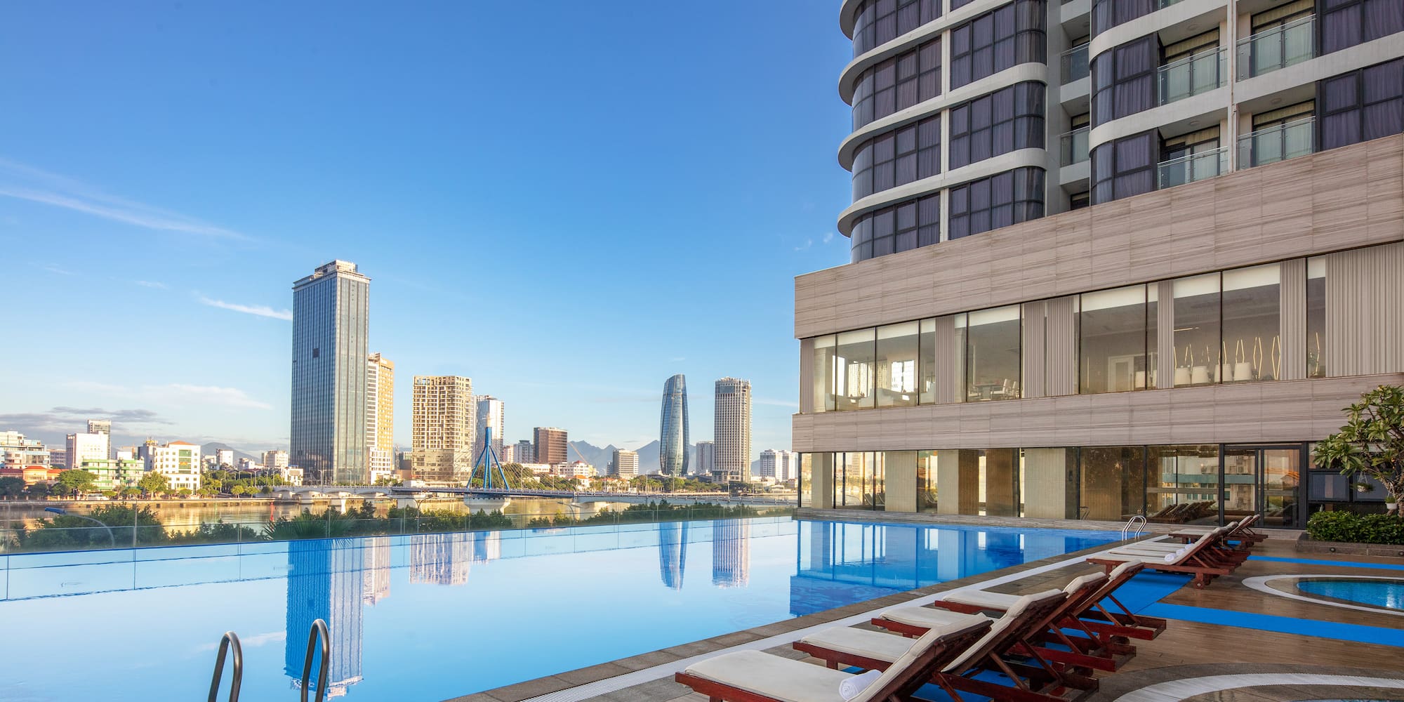 a pool with chairs and a building in the background
