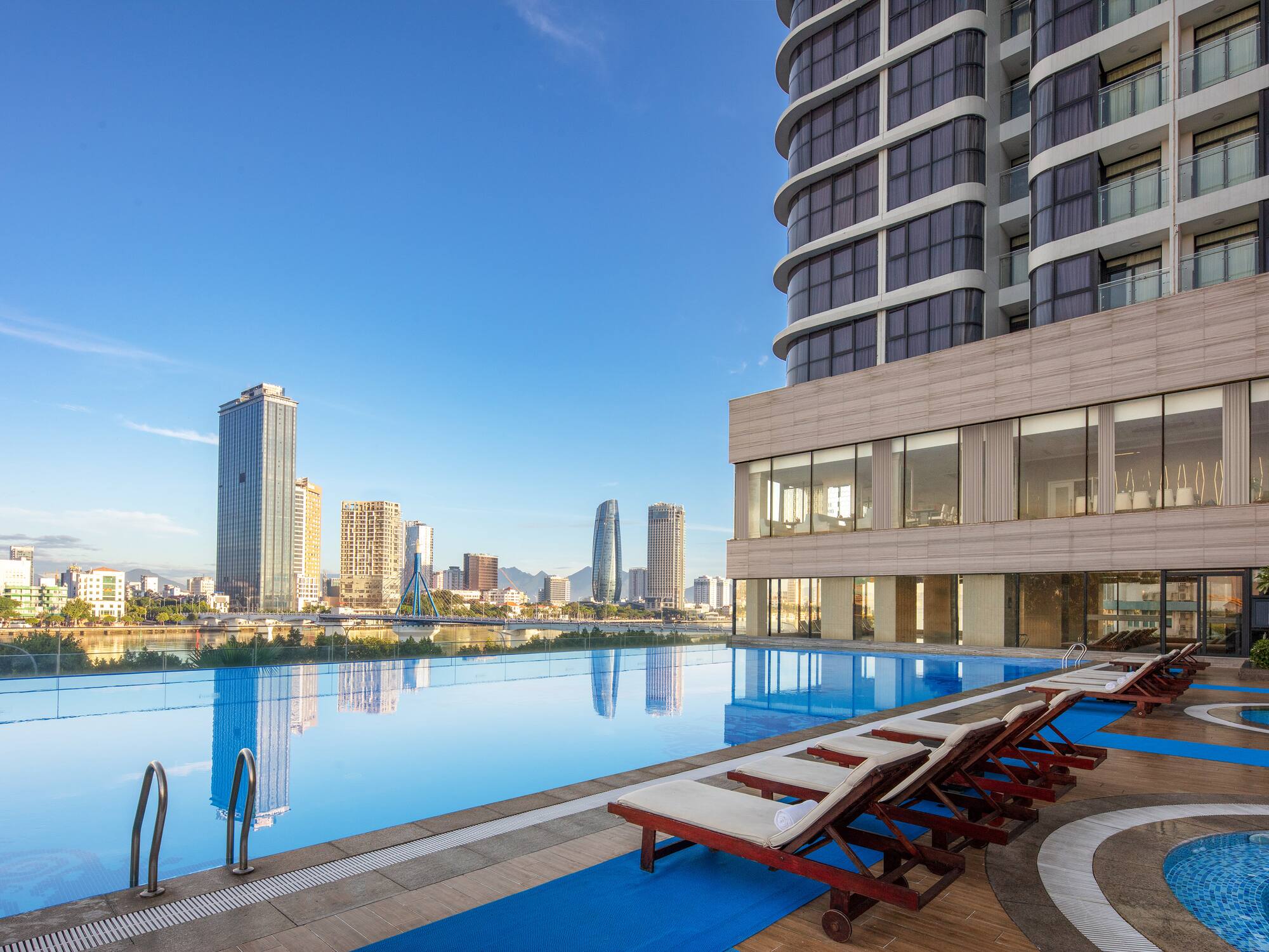 a pool with chairs and a building in the background
