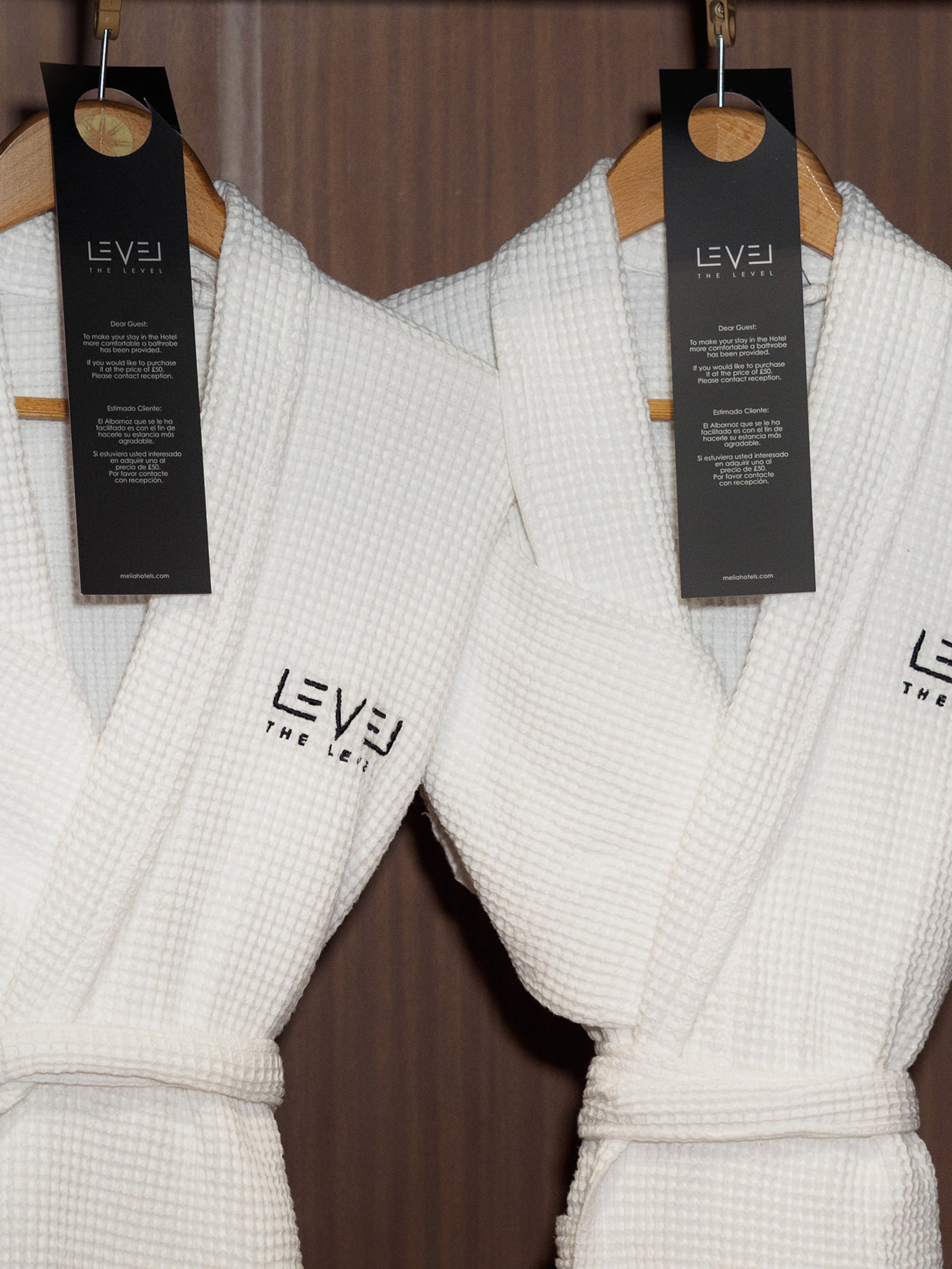 a couple of white bathrobes with black tags on swingers