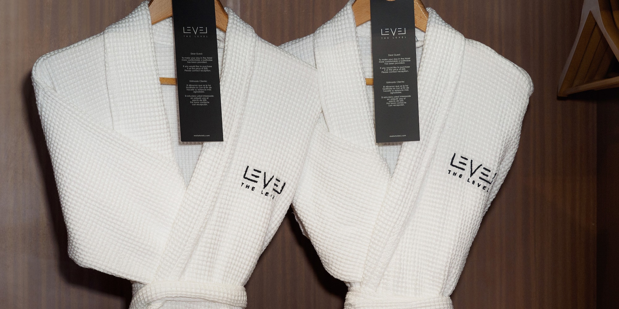 a couple of white bathrobes with black tags on swingers