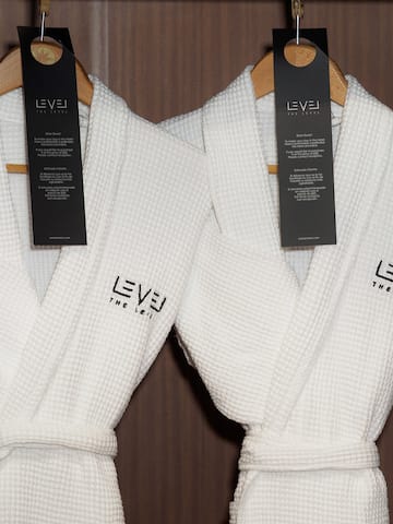 a couple of white bathrobes with black tags on swingers