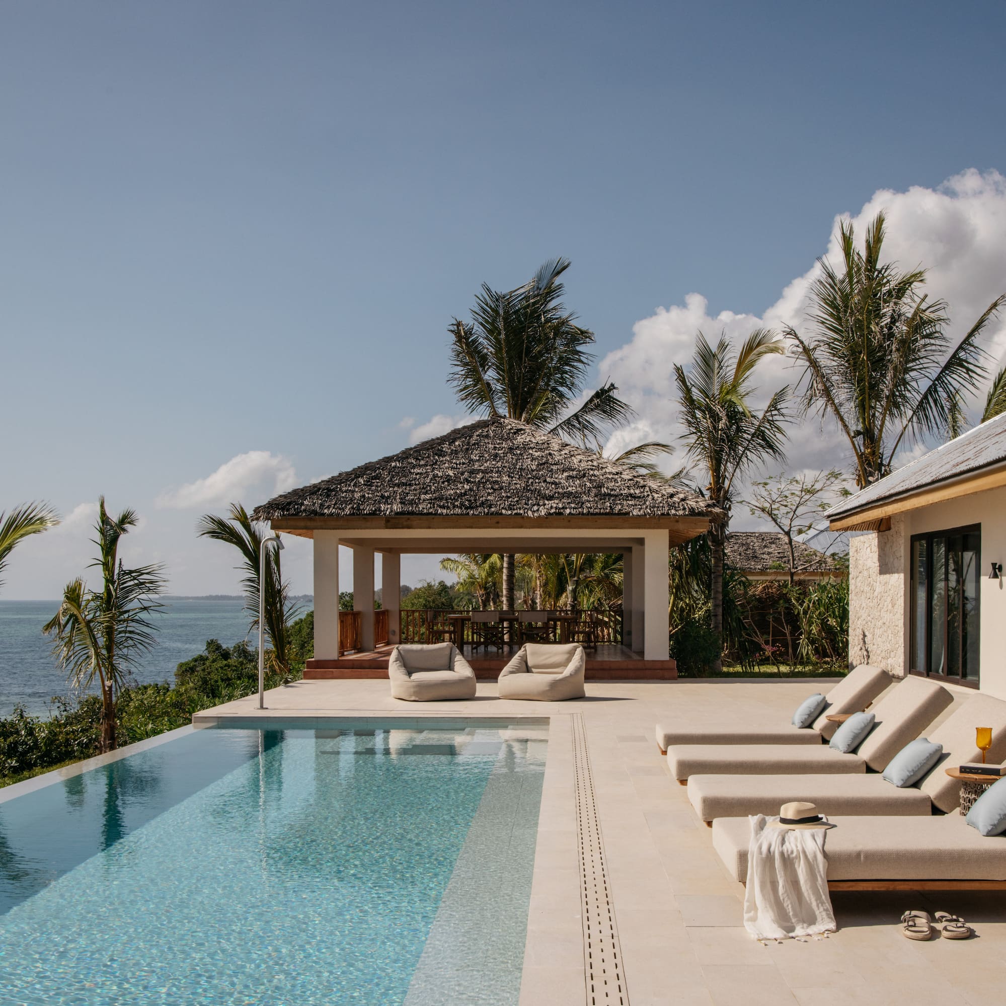 a pool with lounge chairs and a gazebo next to it