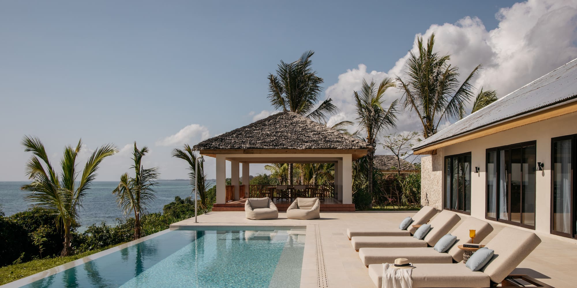 a pool with lounge chairs and a gazebo next to it