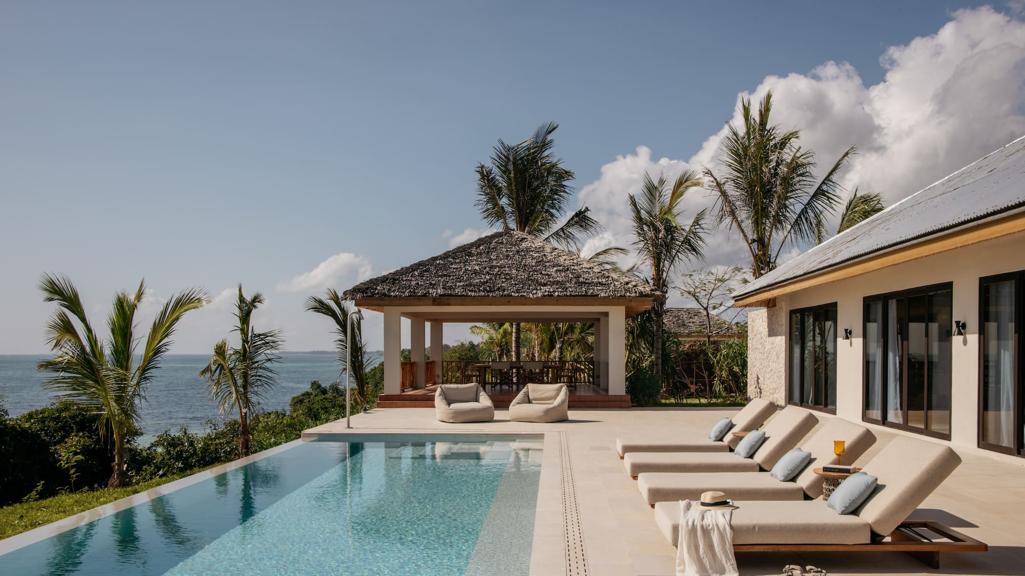 a pool with lounge chairs and a gazebo next to it