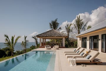 a pool with lounge chairs and a gazebo next to it