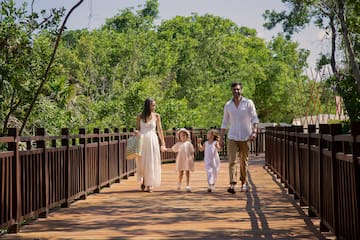 a man and woman walking on a bridge with two children