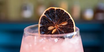 a glass with a slice of orange on top of it
