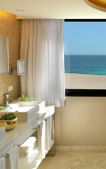 a bathroom with a large window overlooking the ocean