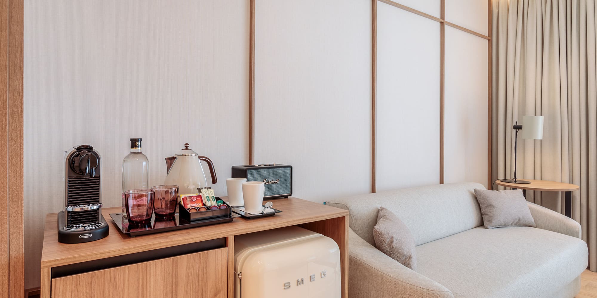 a room with a couch and a small refrigerator