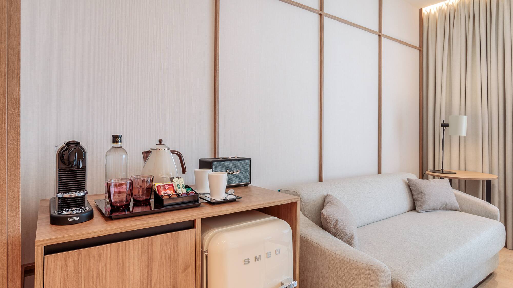 a room with a couch and a small refrigerator