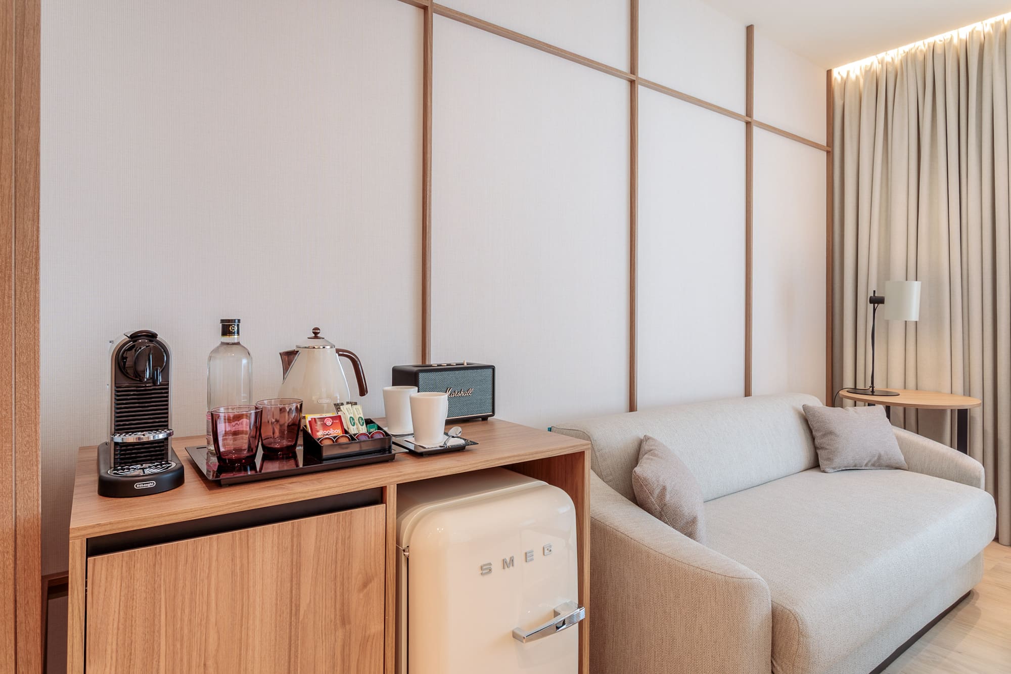 a room with a couch and a small refrigerator