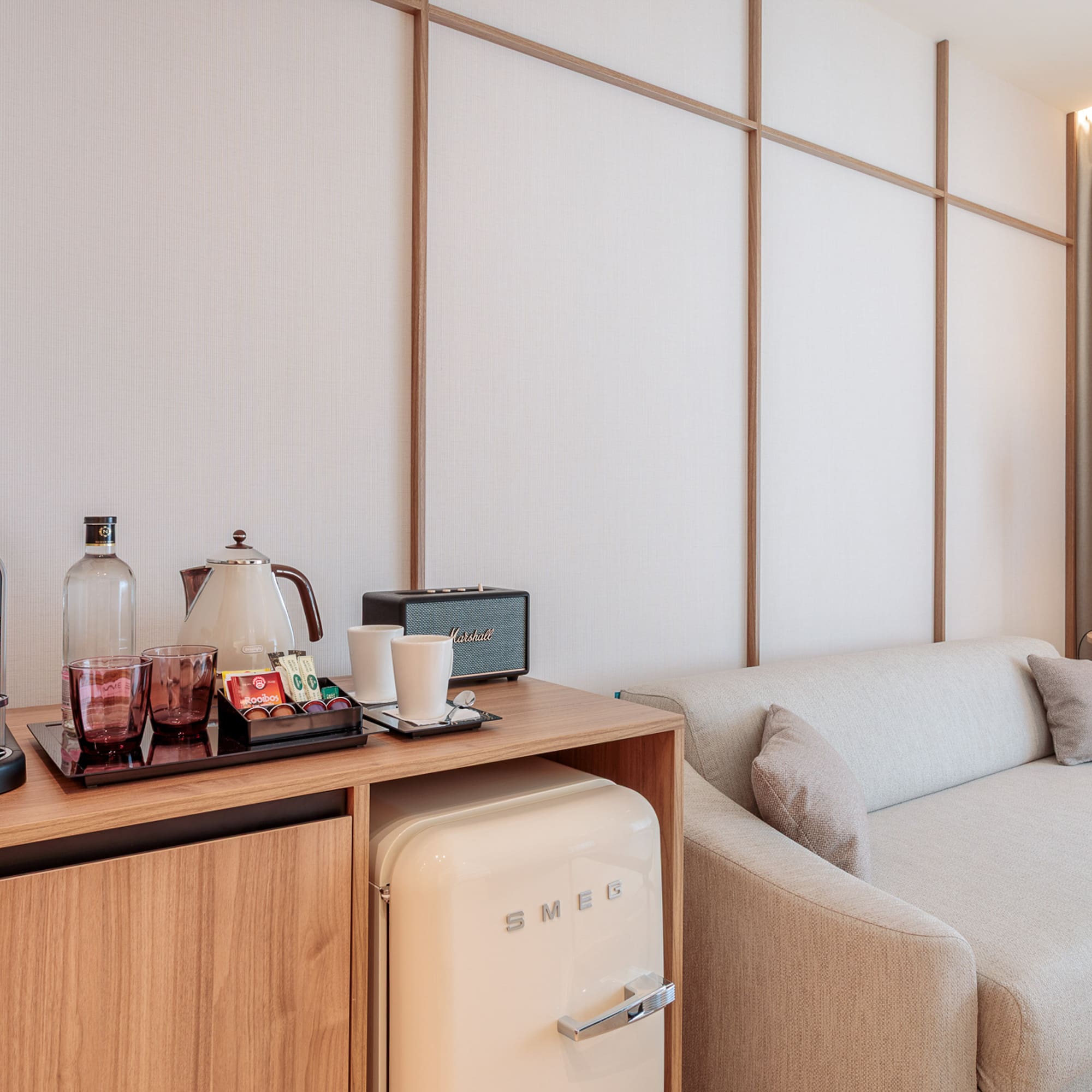 a room with a couch and a small refrigerator