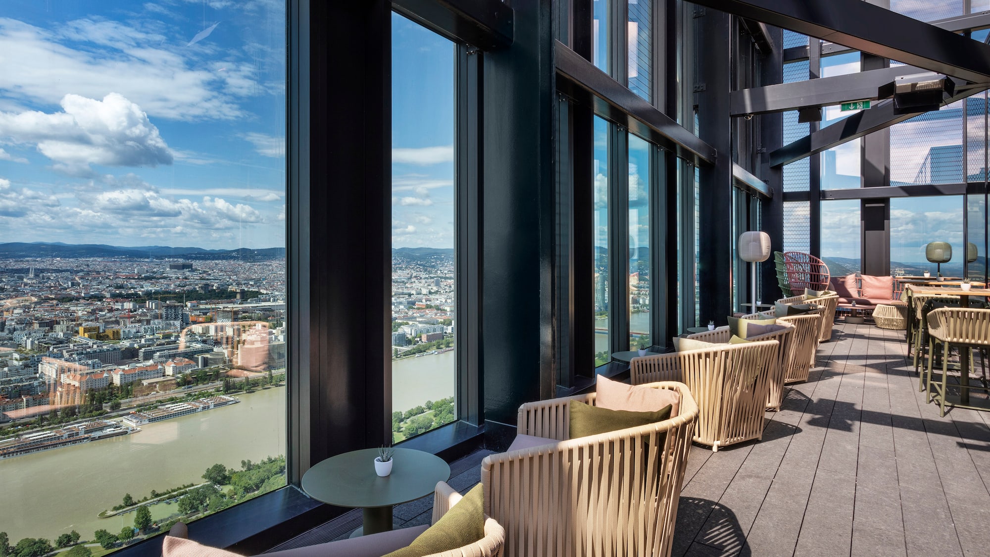 a room with chairs and tables and a view of a city