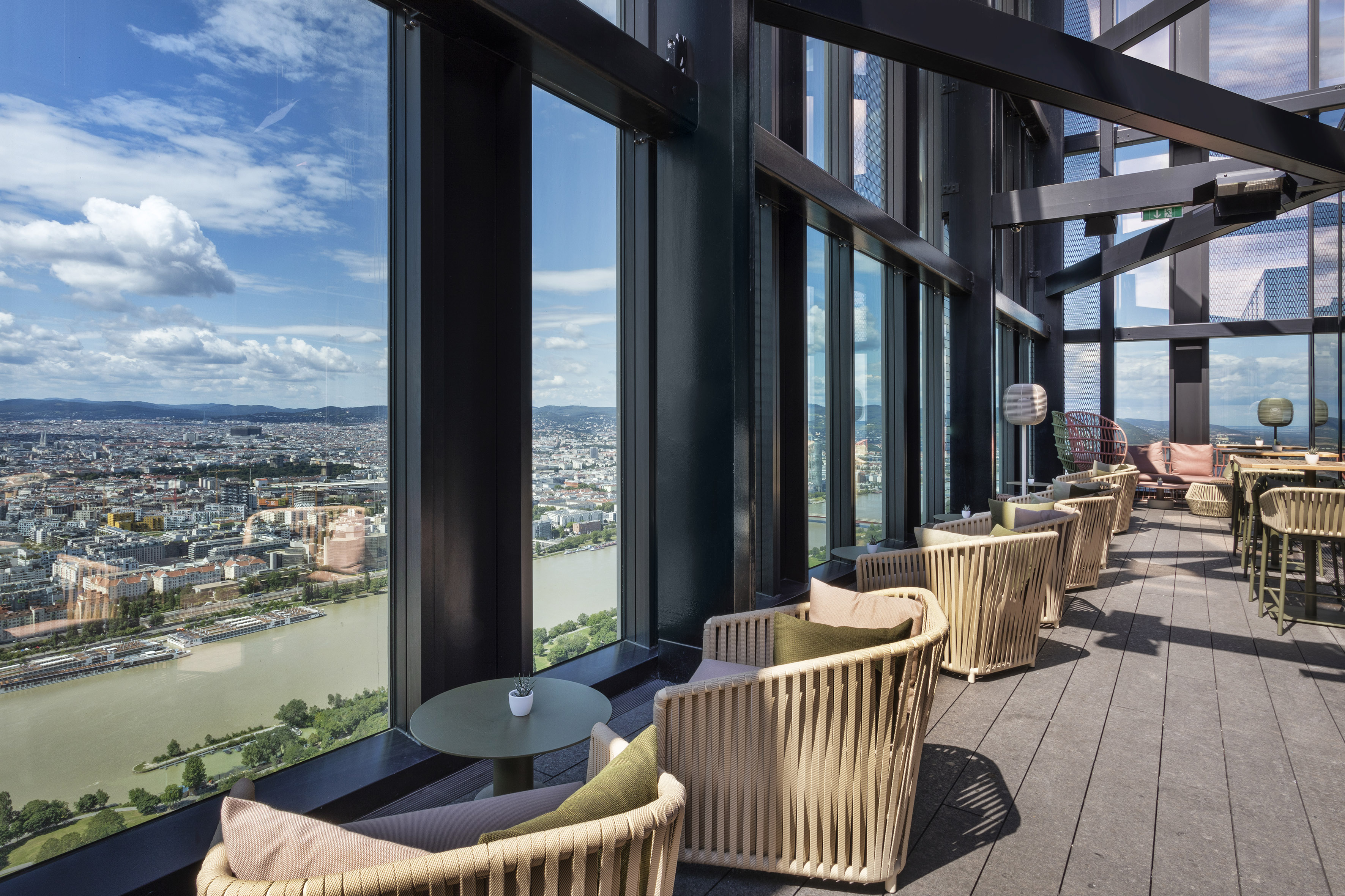 Modern rooftop lounge with panoramic city and river views.