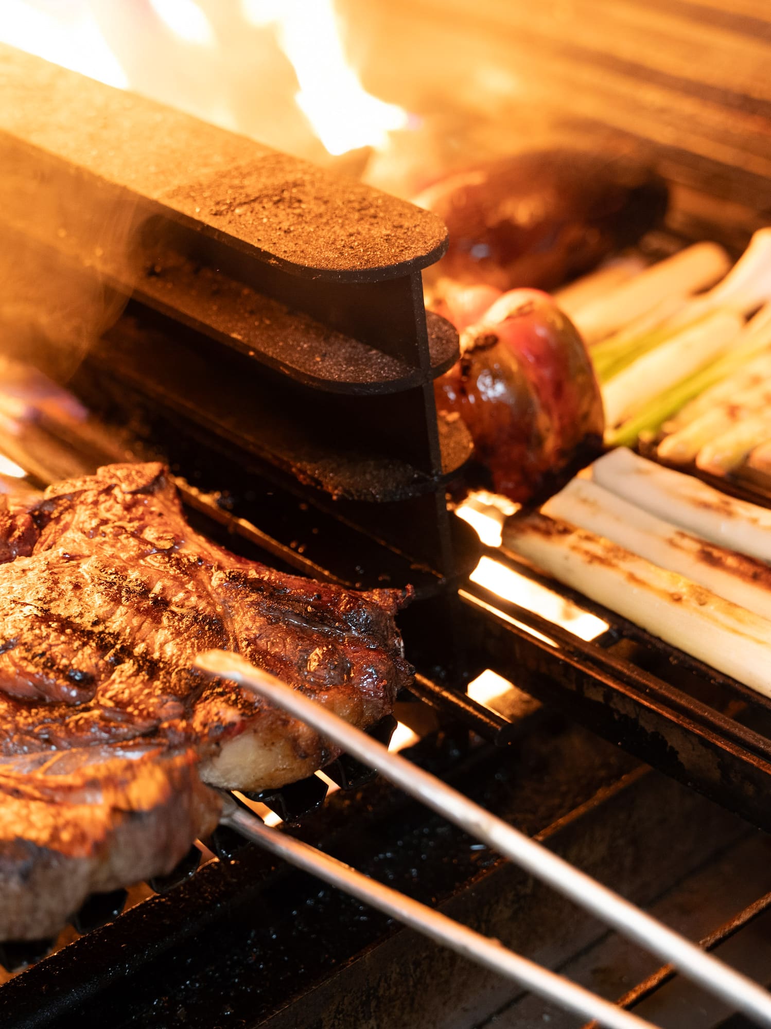 meat on a grill with flames