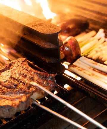 meat on a grill with flames