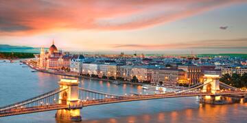 a bridge over a river with a city in the background