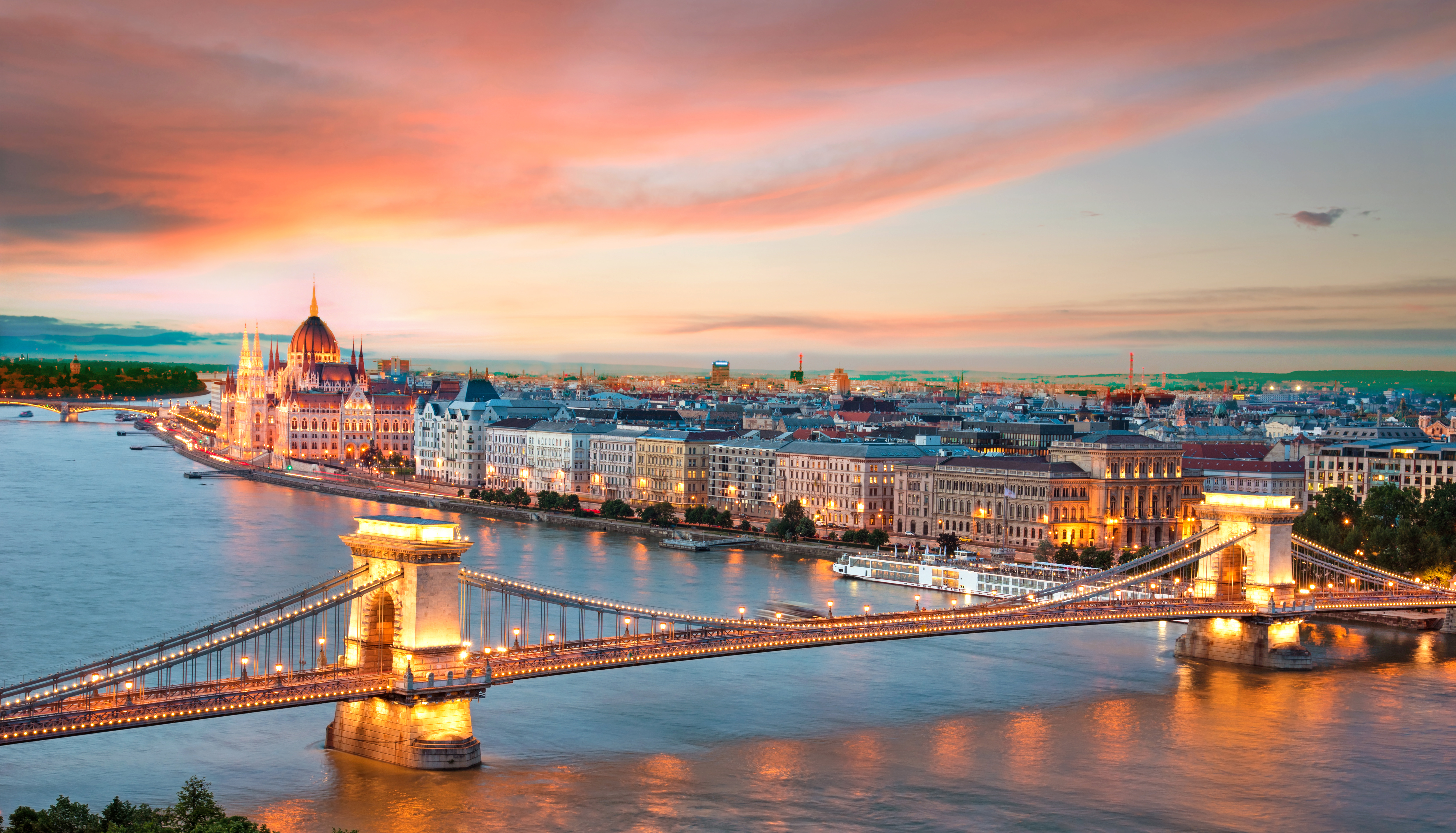 a bridge over a river with a city in the background