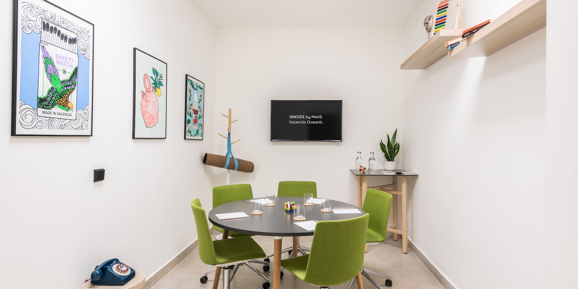 a room with a round table and green chairs