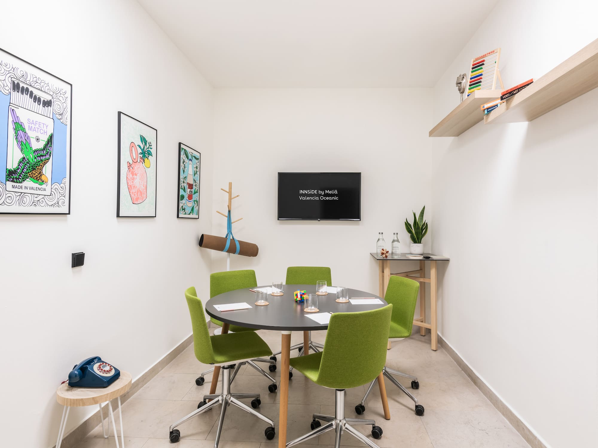 a room with a round table and green chairs