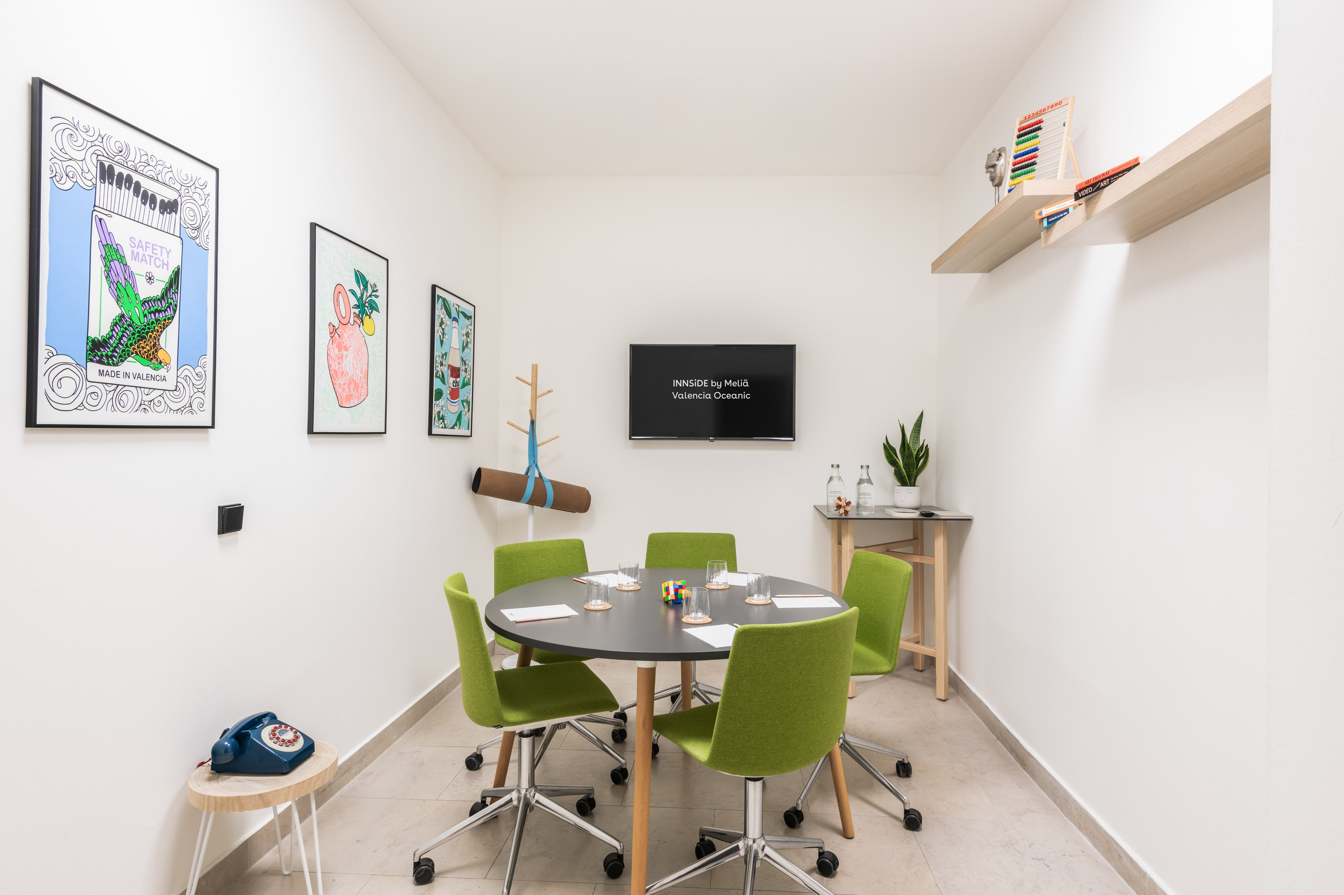 a room with a round table and green chairs