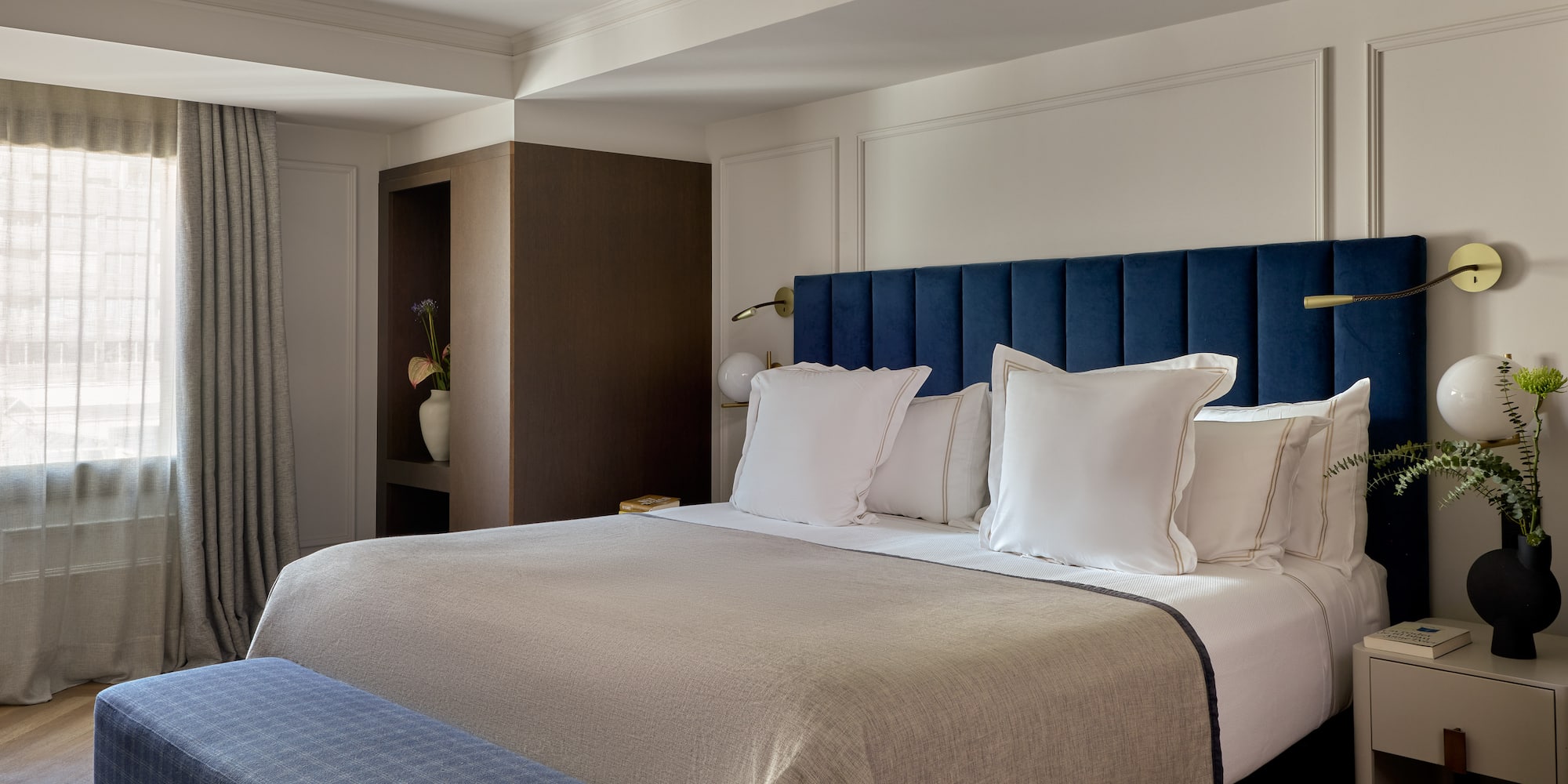 a bed with pillows and a blue headboard in a hotel room