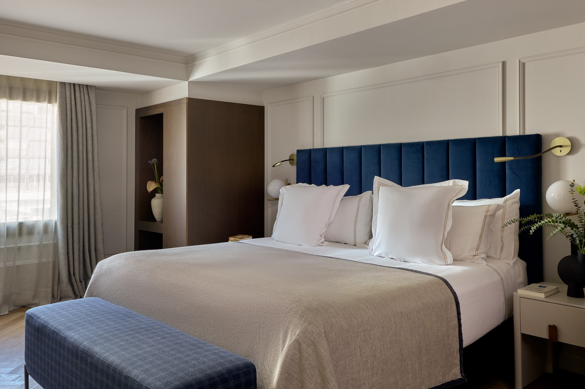 a bed with pillows and a blue headboard in a hotel room