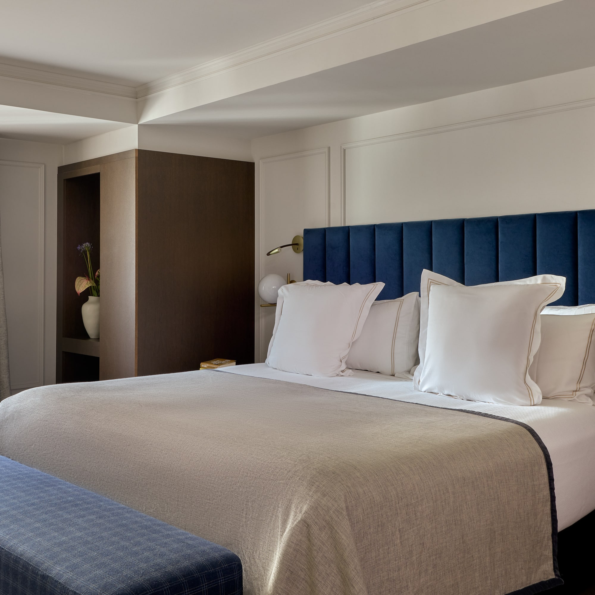 a bed with pillows and a blue headboard in a hotel room
