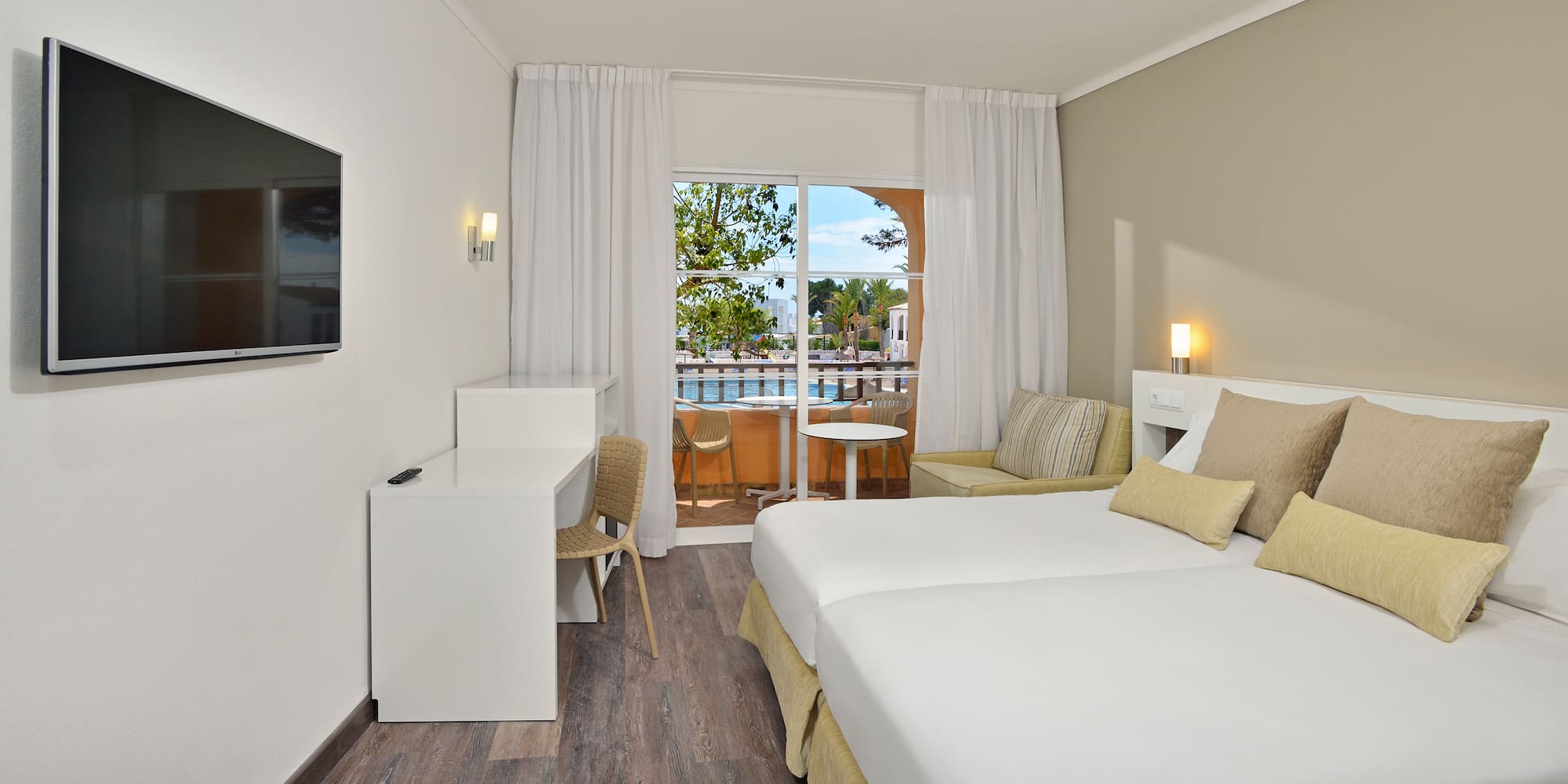 a room with two beds and a table and chairs