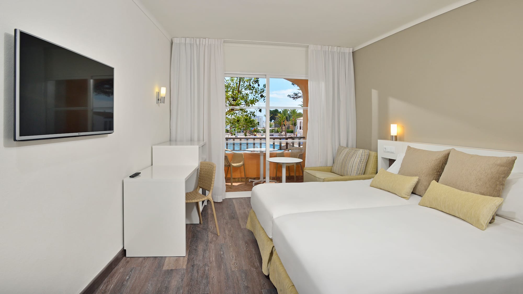 a room with two beds and a table and chairs