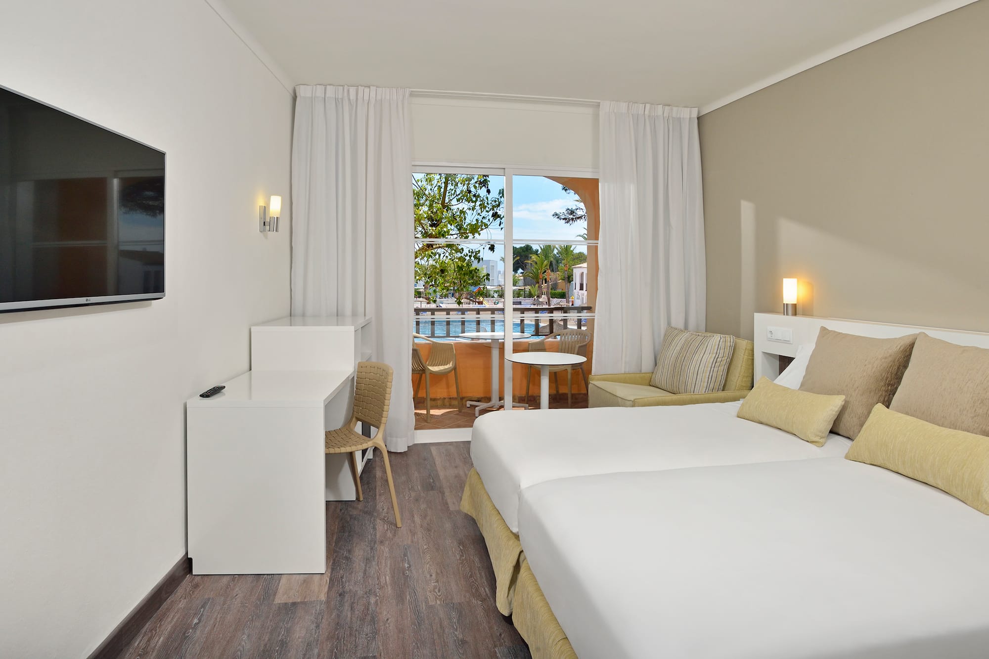 a room with two beds and a table and chairs