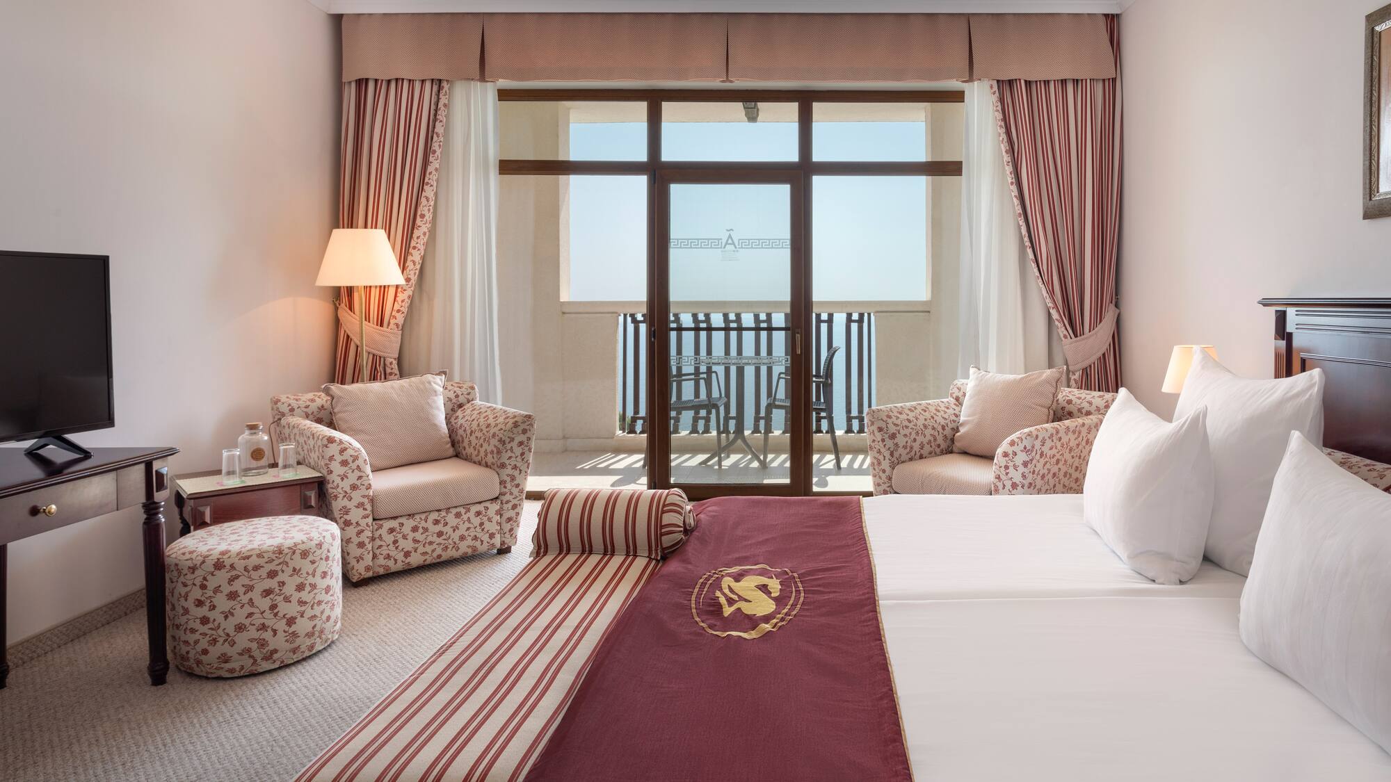 a hotel room with a bed and chairs