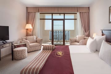 a hotel room with a bed and chairs