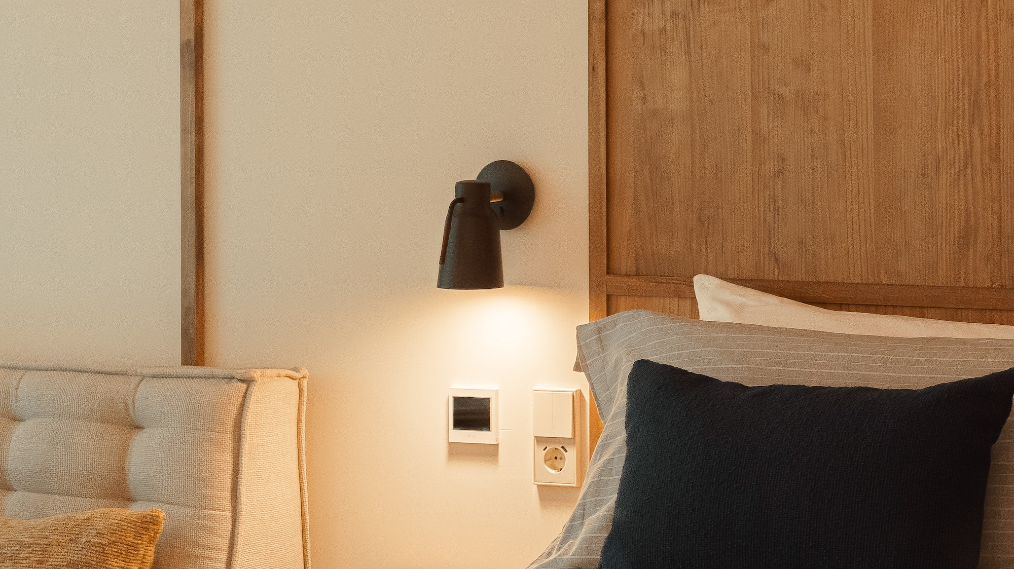 a bed with a black pillow and a wood headboard