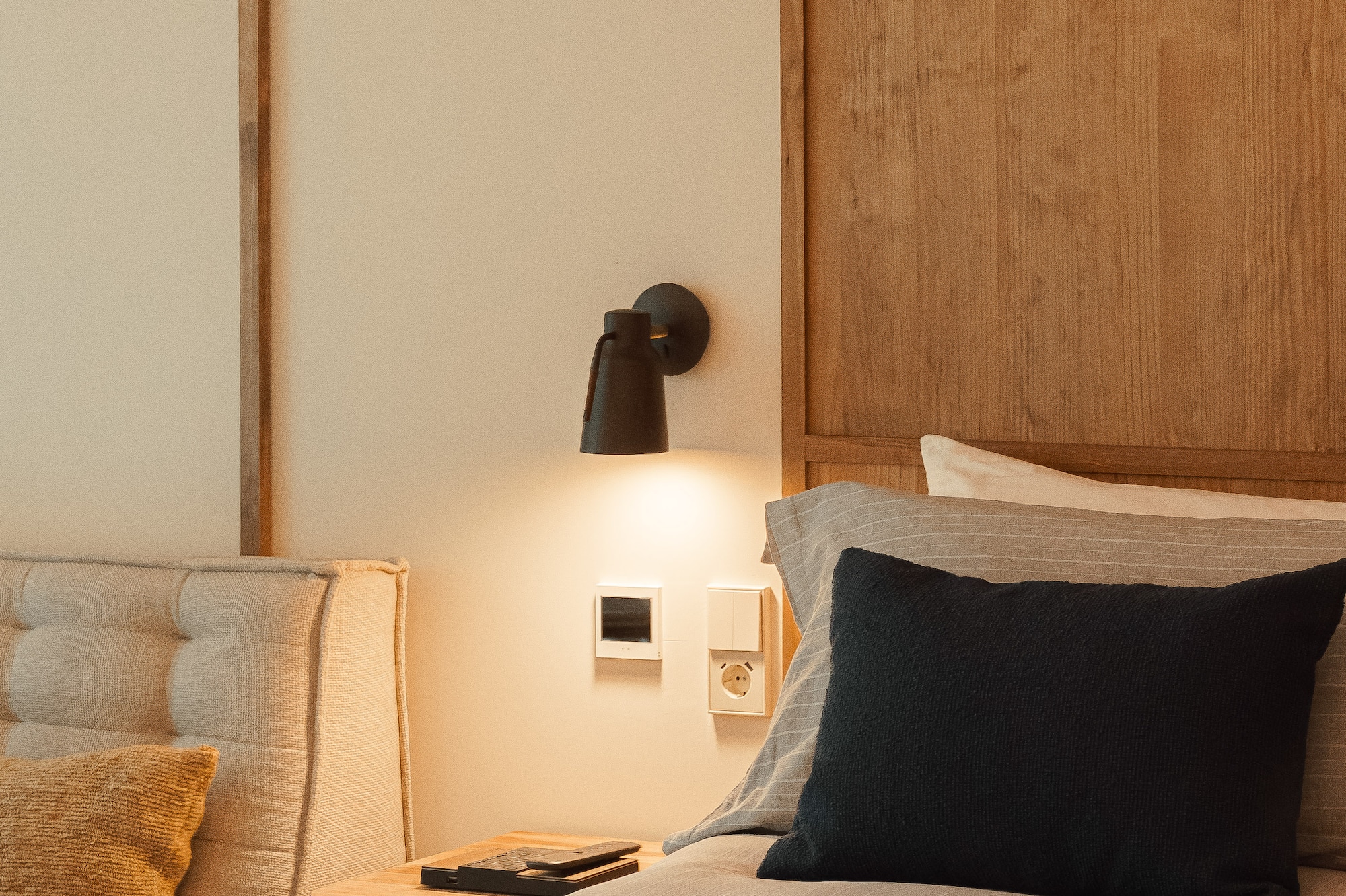 a bed with a black pillow and a wood headboard