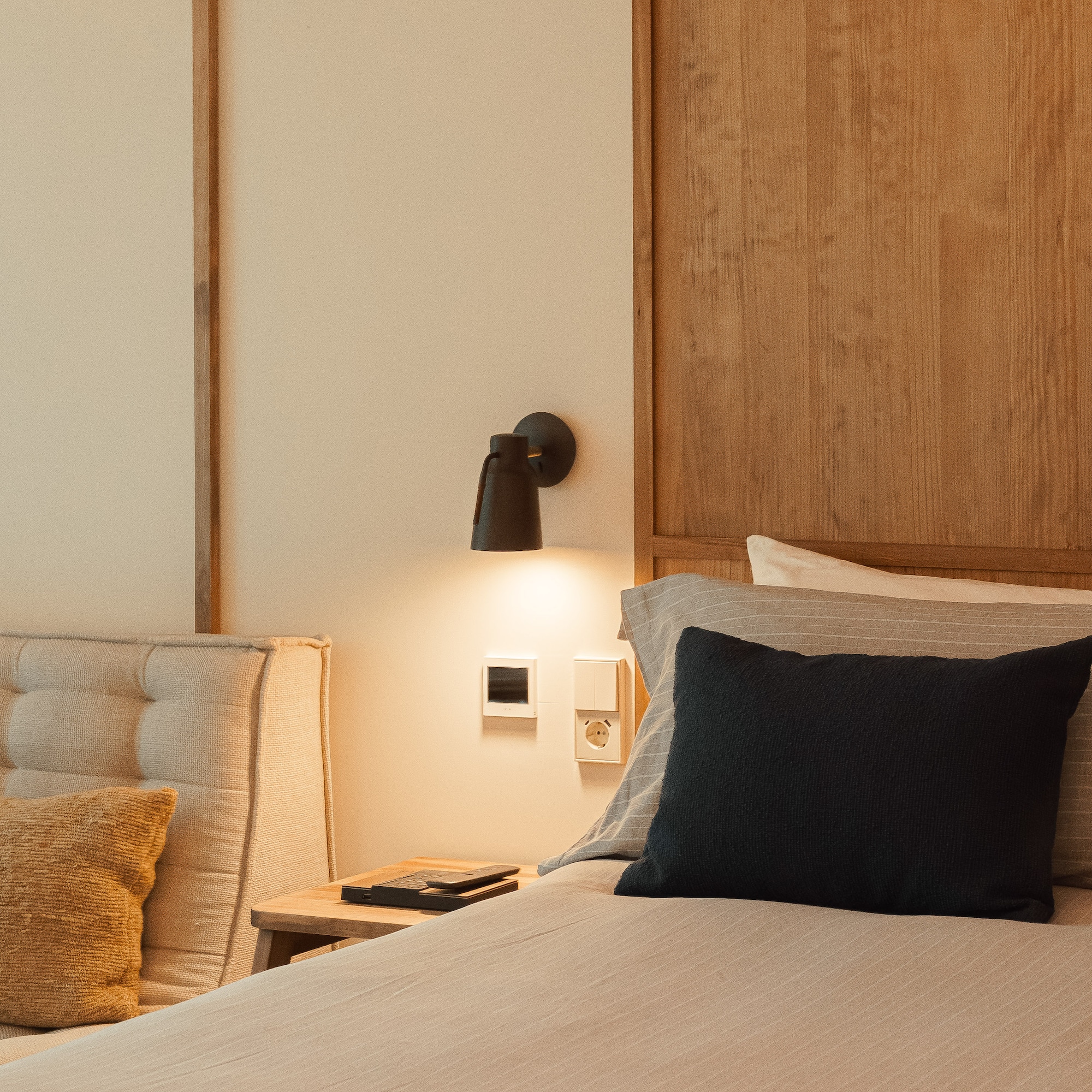 a bed with a black pillow and a wood headboard