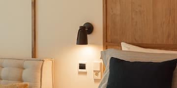 a bed with a black pillow and a wood headboard