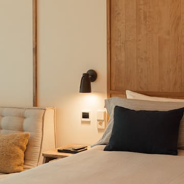 a bed with a black pillow and a wood headboard